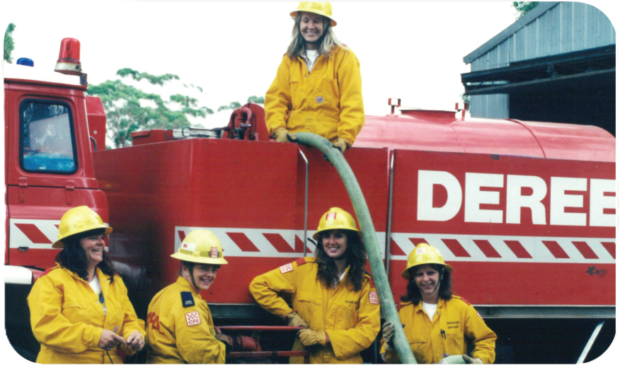 Female members, circa early 1990s Female brigade members standing beside a red fire truck